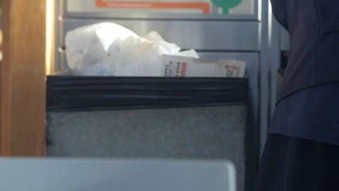 Person is standing in front of a trash can with a bag in it Stock Footage 303540965