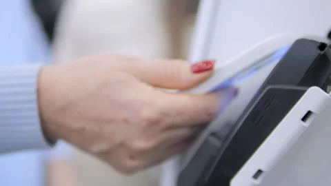 Person is standing in front of a white wall with a black device Stock Footage 298881148