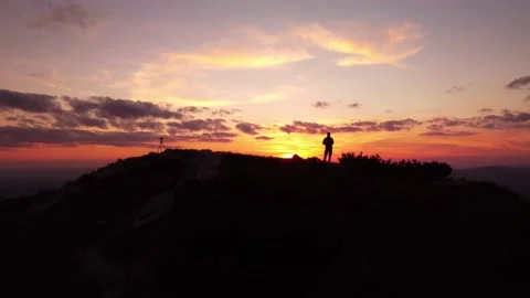 Person standing on rock with epic mountain viewpoint with a sunset drone aerial Stock Footage 201158746
