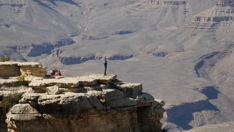Person standing on a rocky ledge Stock Footage 89831440