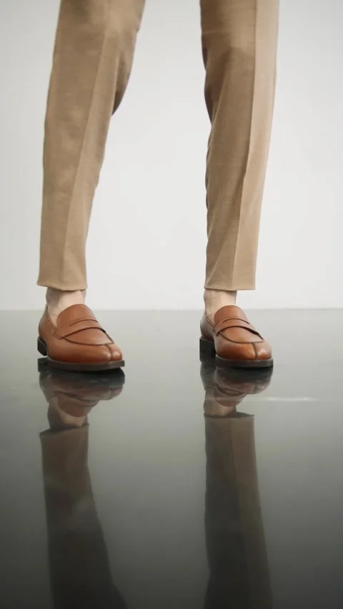 Person standing on shiny surface in brown shoes Stock Footage 274163668