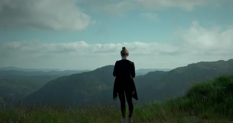 Person standing on top of a mountain looking at other mountains Vidéo 263040253