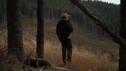 Person stands alone in forest during the day looking at surrounding trees 스톡 동영상 330120724