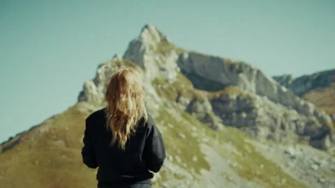 A person stands on a path looking at the mountains of Montenegro with views of Stock Footage 327012114