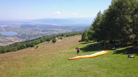 Person stands on side of mountain ready to start flight paragliding. Stock-Footage 253617212