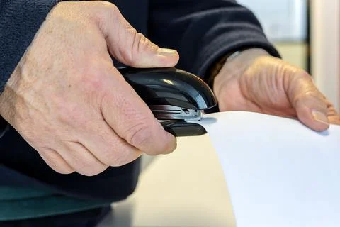 Person stapling documents together on office desk Fotos Stock