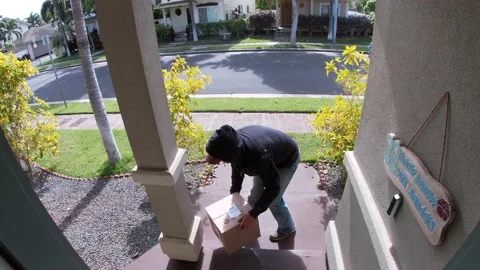 Person stealing delivery package from porch steps, surveillance camera view Stock Footage