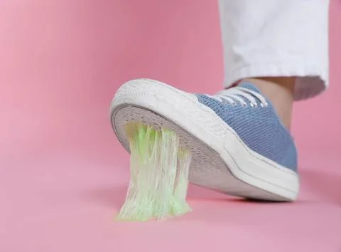 Person stepping into chewing gum on pink background, closeup. Space for text Stock Photos