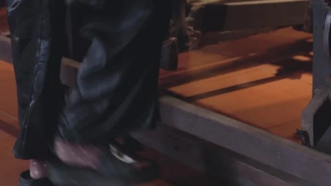 Person stepping on a platform in a dimly lit space at night Stock Footage 308835847