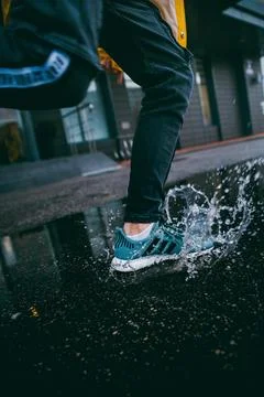 Person stepping on a puddle Stock Photos