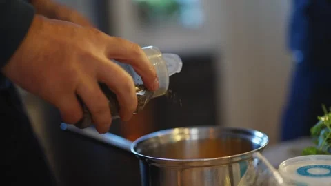 A person is stirring a pot with a spoon in a kitchen Stock Footage 295367467