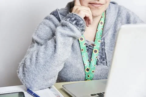 Person studies or works using a sunflower lanyard, invisible disabilities sym Stock Photos