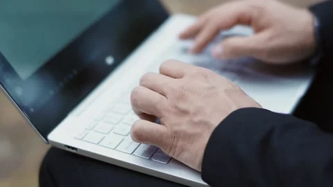 A person in a suit is quickly typing text on a laptop Stock Footage 147329009