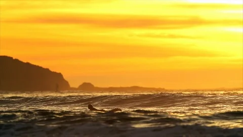 Person surfing at sunset. Vidéo 88406219