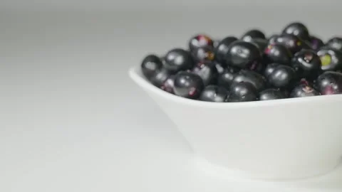 A person takes Java plum fruits from a bowl 4k short Video stock 252206946