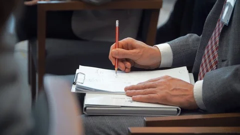 Person takes notes in pencil in a notebook during a conference 스톡 동영상 104058421