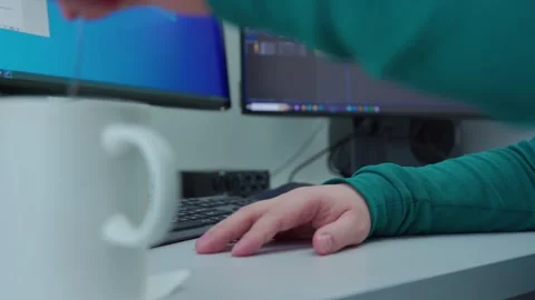 A person takes a rest at a computer with a white cup of coffee Stock Footage 270767627
