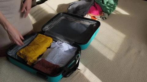 A person takes things out of a suitcase after returning from a trip. Stock Footage 329479230