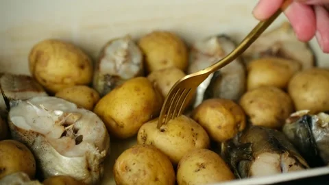 Person taking cooked potato from baking dish with pollock fish Vídeo Stock 337902145