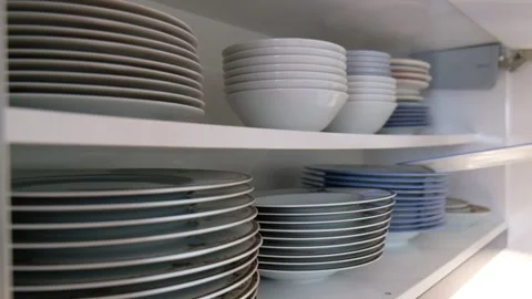 Person Taking Large Dinner Plates from a Two-Shelf Kitchen Cabinet Video stock 302688205