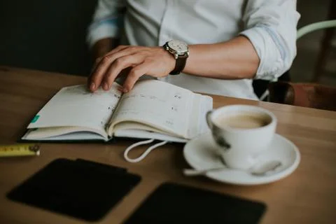 Person taking notes in a notebook while working from home Stock Photos
