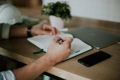 Person taking notes in a notebook while working from home Foto stock