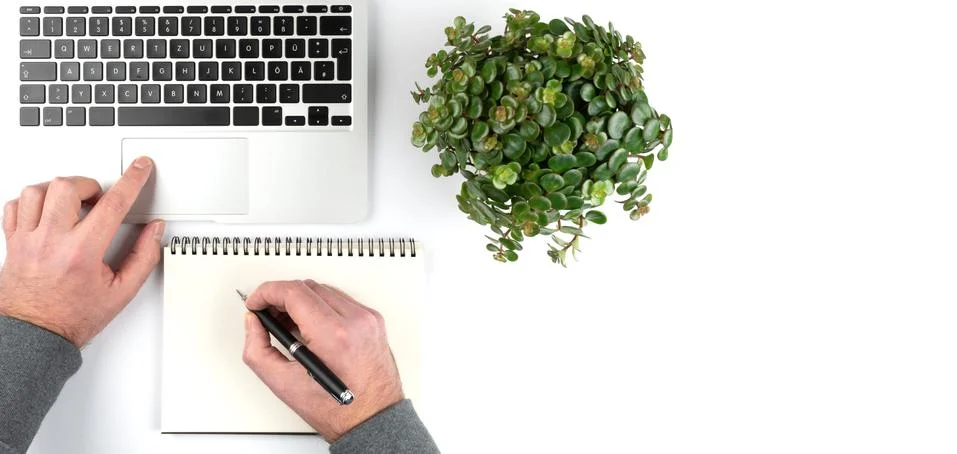 Person taking notes on notepad white working on laptop computer 스톡 사진