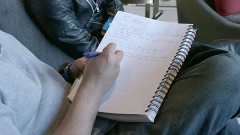 Person Taking Notes in Spiral Notebook During Business Meeting Stock Footage 343969624