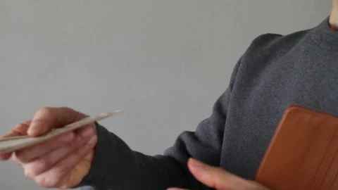 A person taking out banknotes from a wallet and handing them over Stock Footage 324547833