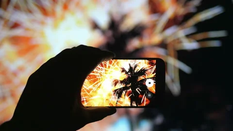 Person taking picture of the fireworks exploding show on tropical island in 4K Stock Footage 143106697