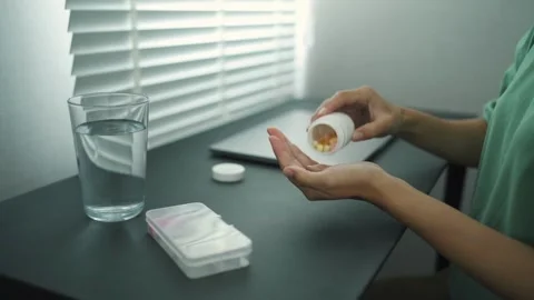 A person taking pills from weekly pill box. daily medicine Dietary vitamin Stock-Footage 336586489