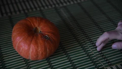 Person taking pumpkin from table Stock Footage 259368016