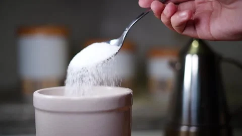 Person taking a spoon full of sugar or salt from a jar and dropping it in slow m Stock Footage 247336170