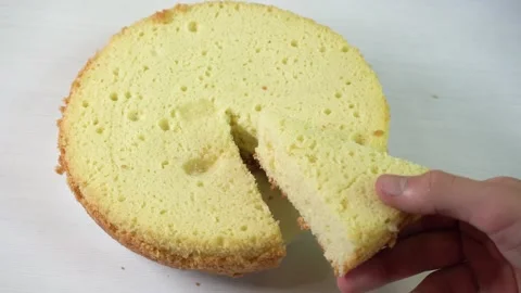 Person taking triangle piece of fresh biscuit cake with hand from white plate Stock Footage 223403209