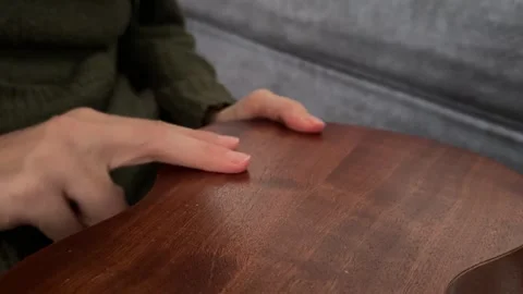 Person tapping fingers rhythmically on back of ukulele body close up at home, Stock Footage 337105474