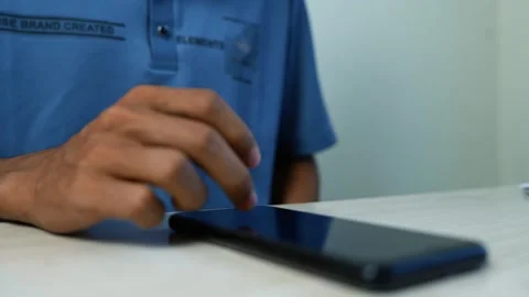 Person Tapping a Tablet on a White Table, Close-up of a person in a blue sh.. Stock Footage 345120299