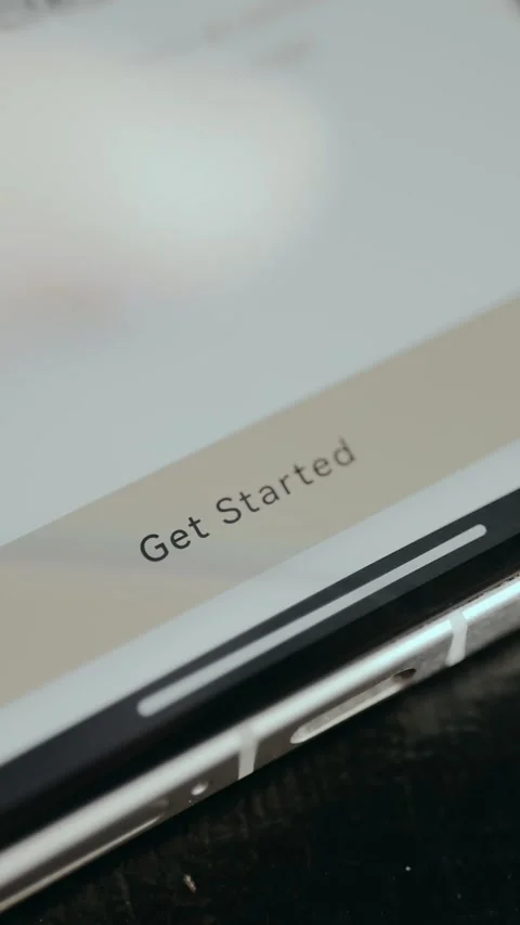 Person taps the button labeled Get Started from a mobile app Video stock 330258210