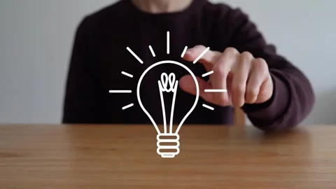 Person Taps On Glowing Light Bulb Icon On Wooden Table To Make It Disappear Stock Footage 318299931