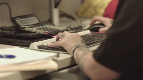 PERSON WITH TATTOOS OPERATES KEYBOARD Stock Footage 217014706