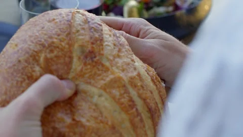A person tears off a piece of bread at dinner Stock Footage 250959190