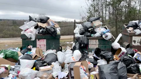 Person throwing a bag of trash at an overflowing county residential dump Furn Stock Footage 171726567