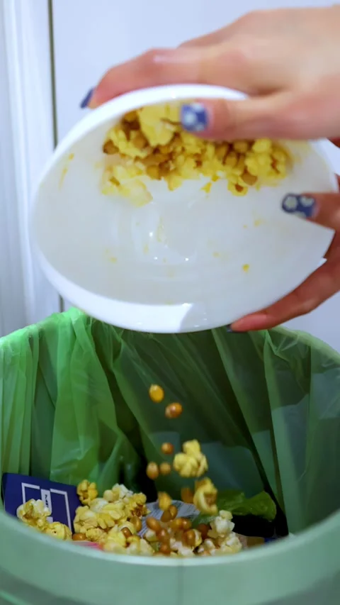 Person Throwing Leftover Popcorn Into Kitchen Trash Can Stock Footage 337757251