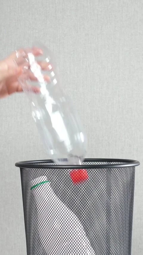 Person throwing plastic bottles into a trash can for recycling, highlighting Stock Footage 343908469