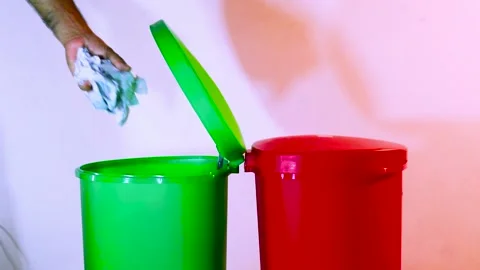 A Person is Throwing Used Papers And Used Bottles Separately Into Trash Bins Stock Footage 170154403