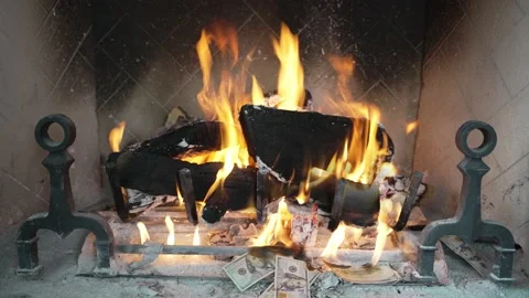 Person throws 100 dollar bills in fireplace and the money burns Stock Footage 231535787