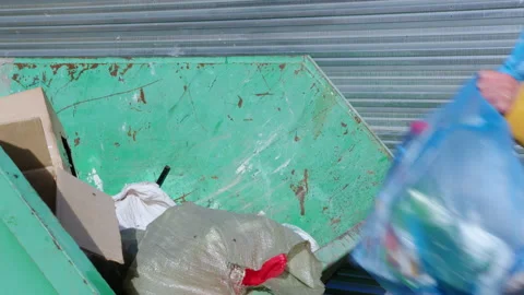 Person throws bag of garbage into dumpster Video stock 170131954
