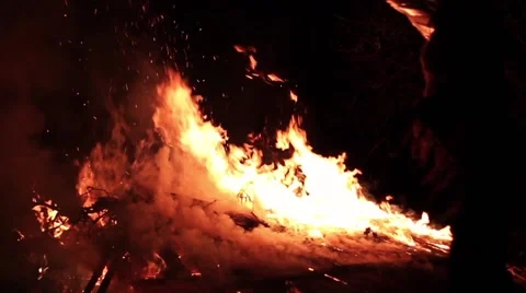 Person throws object into slow motion bonfire. Stock-Footage 45368825