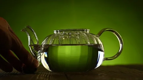 A person throws a tea flower into the boiling water and it opens Stock Footage 125928270