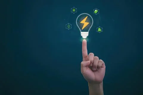 Person touching glowing light bulb with energy icons around Stock Photos