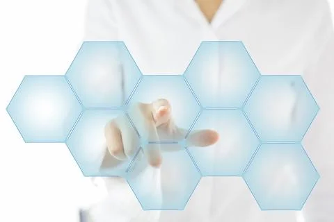 Person touching an hexagonal button on a digital interface Stock Photos